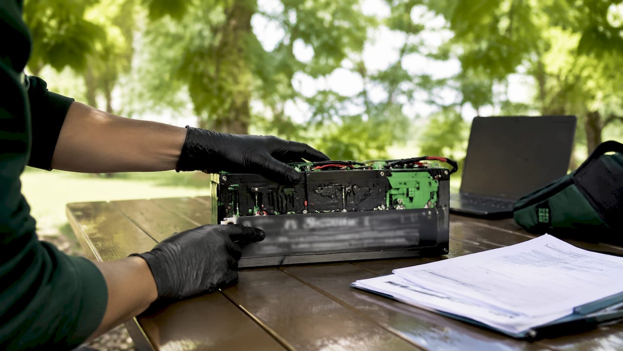 Hands inspecting LiFePO4 battery in lab
