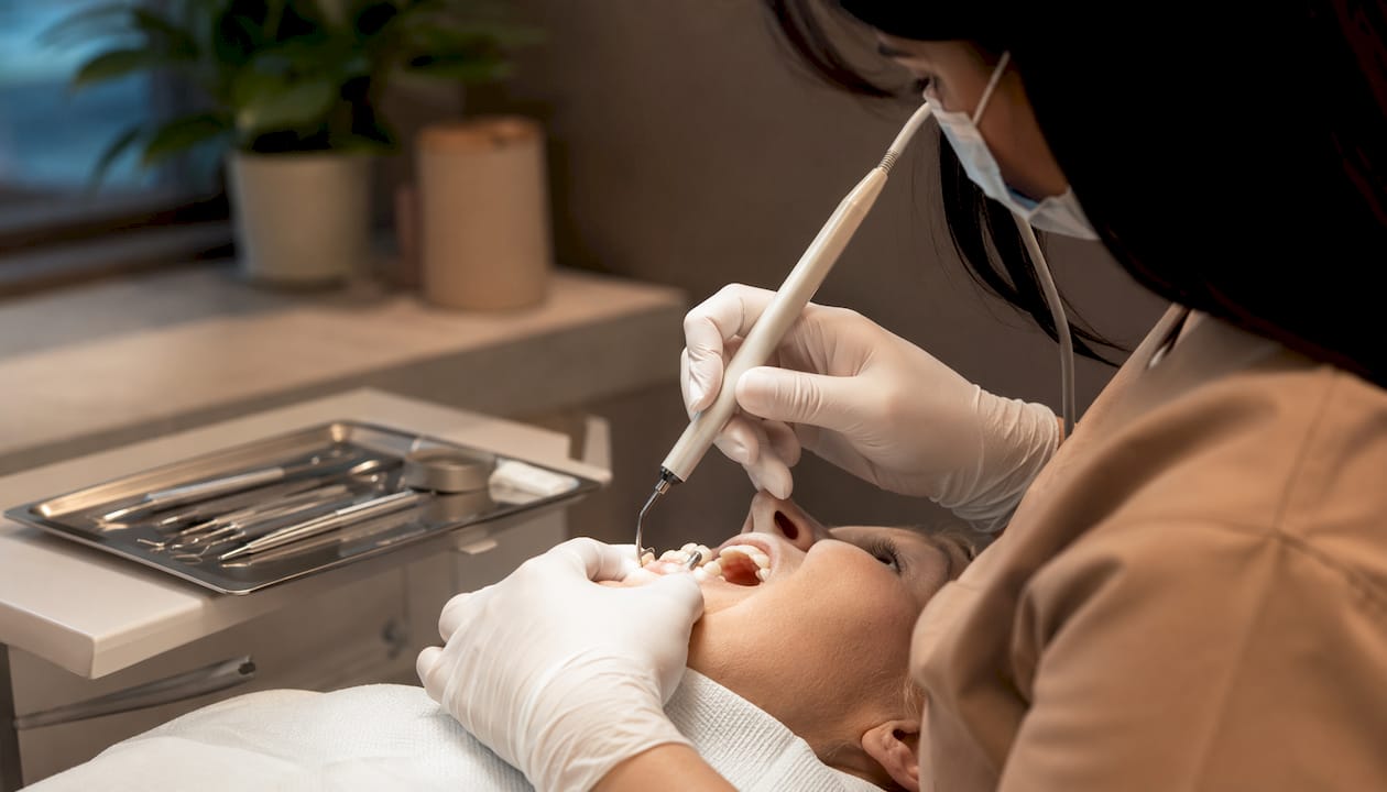 Hands performing nonsurgical cleaning on implant