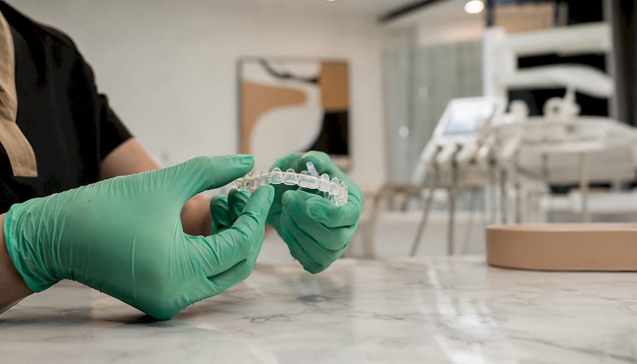 Hands holding teen clear aligner