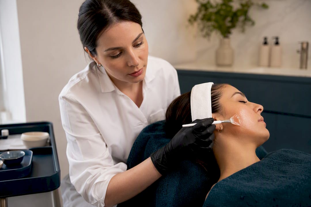Clinician applying chemical peel to cheek