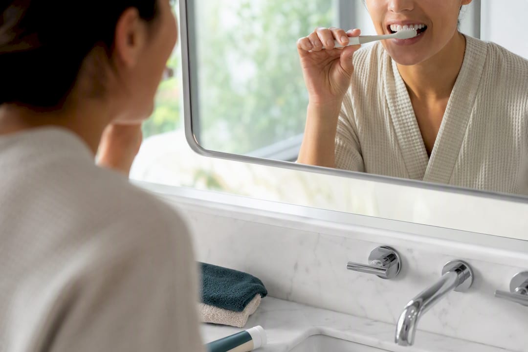 Patient gently brushing teeth with soft toothbrush