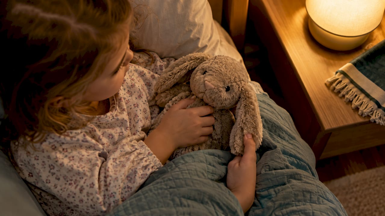 Child reaching for stuffed toy at bedtime