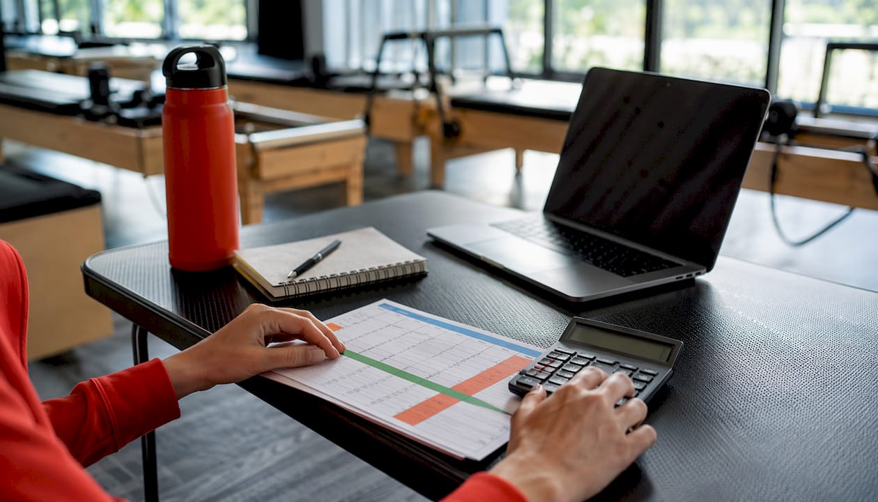 Hands budgeting Pilates studio software costs