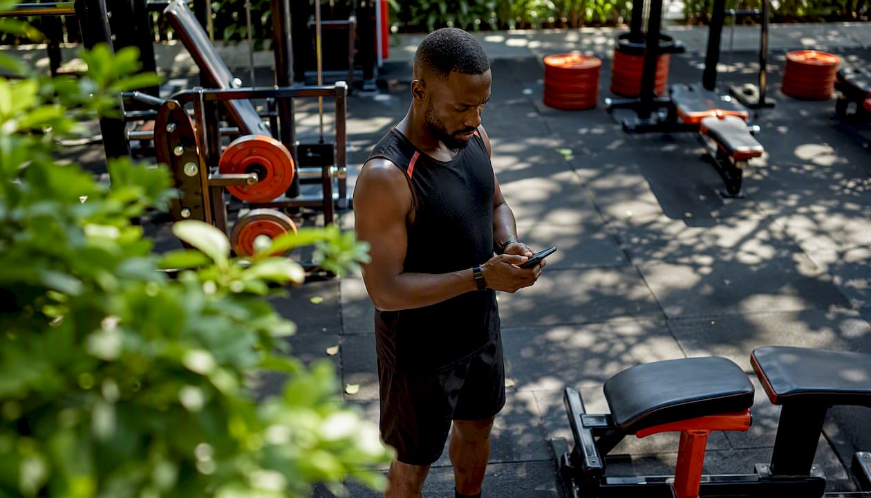 Personal trainer using gym management app on smartphone