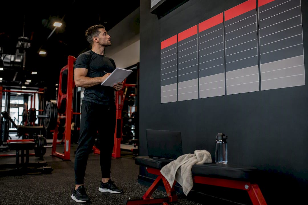 Gym owner reviewing pricing charts in gym
