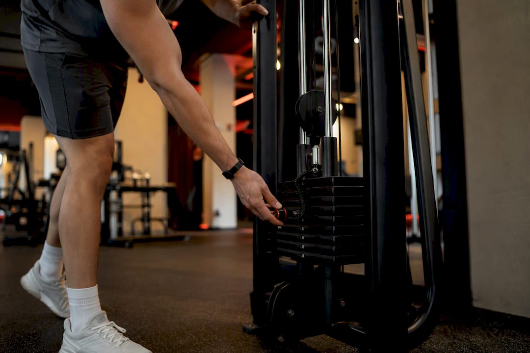 Gym member adjusting cable machine
