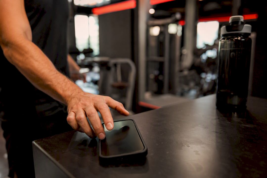 Hand holding smartphone in gym lobby