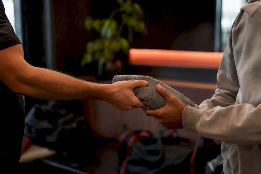 Member handing towel to returning friend