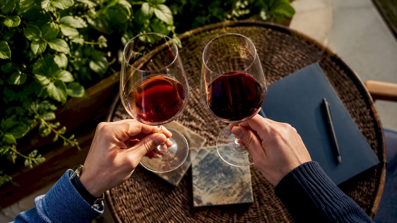 Hands comparing red wines in vertical tasting