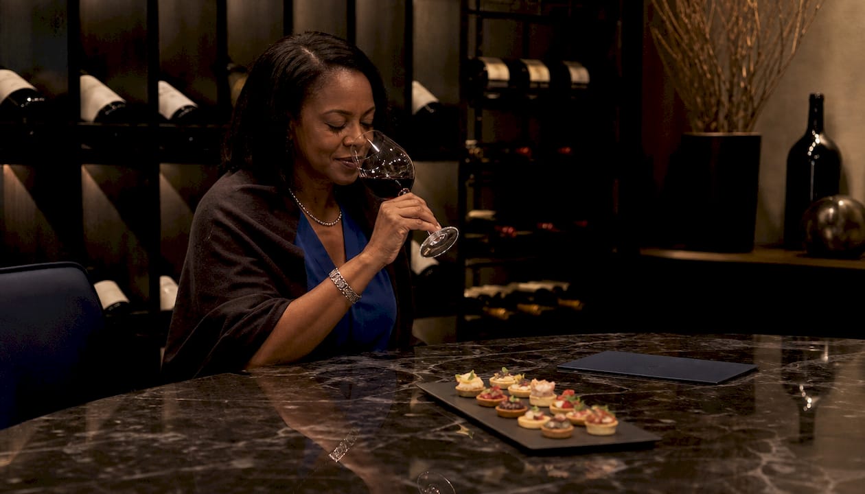 Guest enjoying wine aroma in cellar dining setting