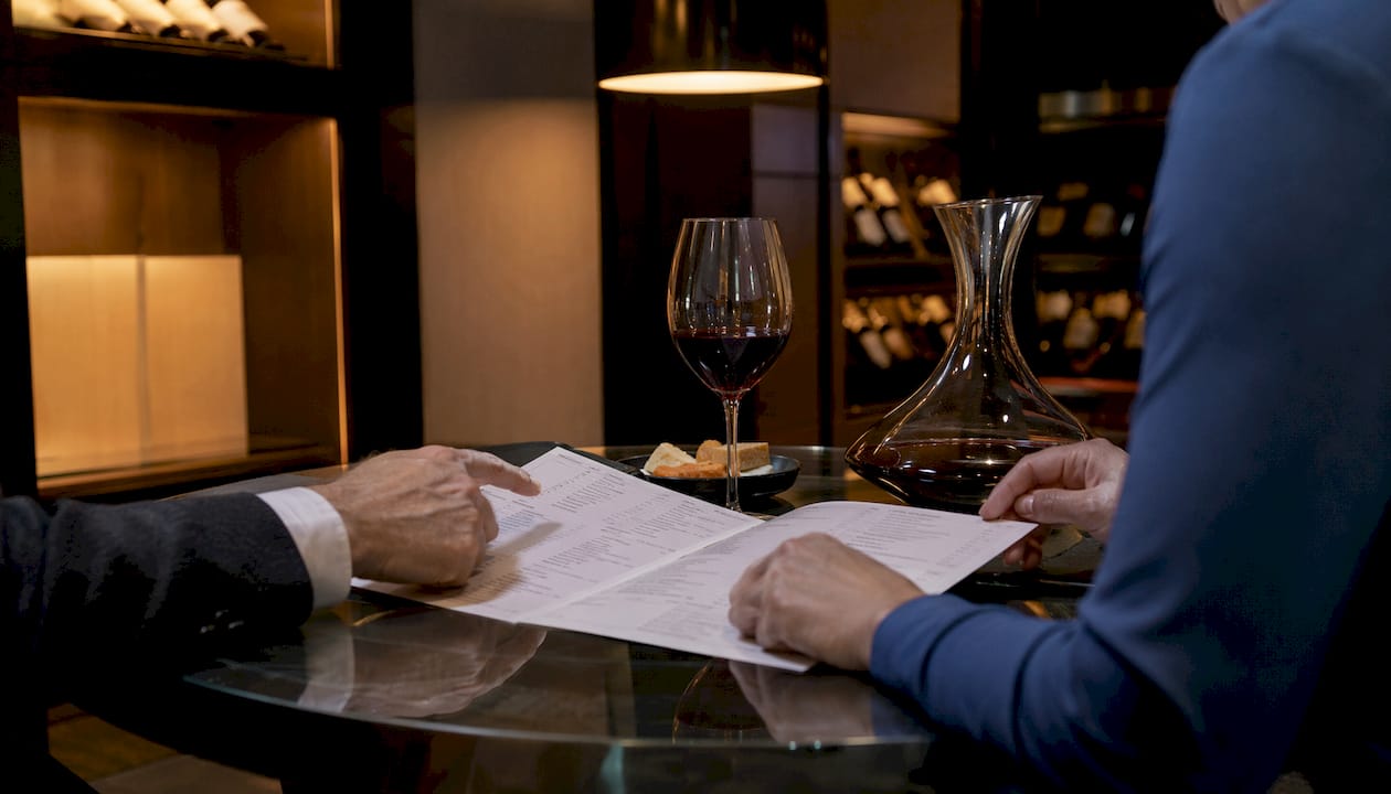 Hands pointing at wine list sections