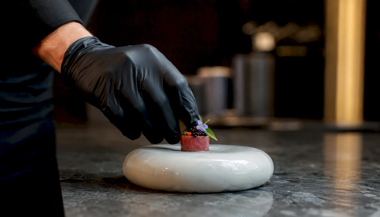 Chef plating amuse-bouche in kitchen