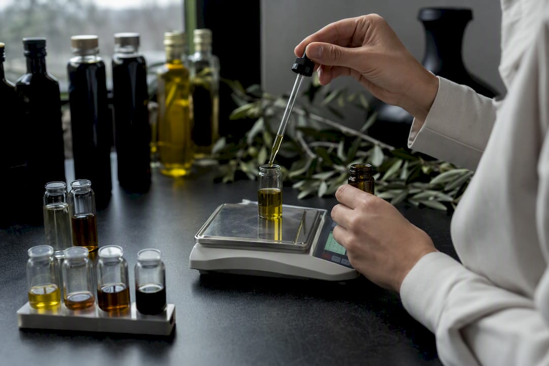 Lab technician measuring olive oil sample in beaker