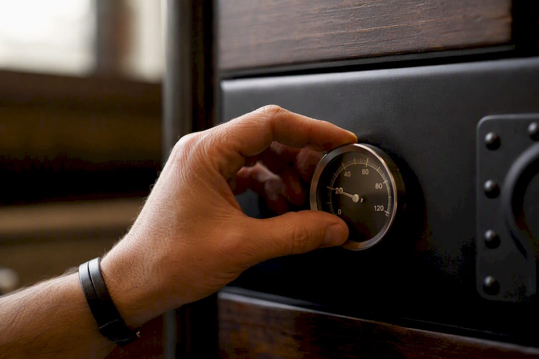 Hand checking smoker thermometer dial