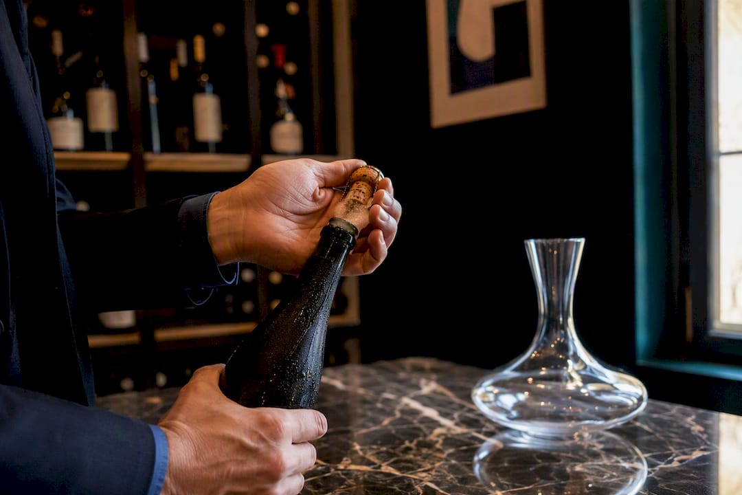 Sommelier uncorking champagne bottle