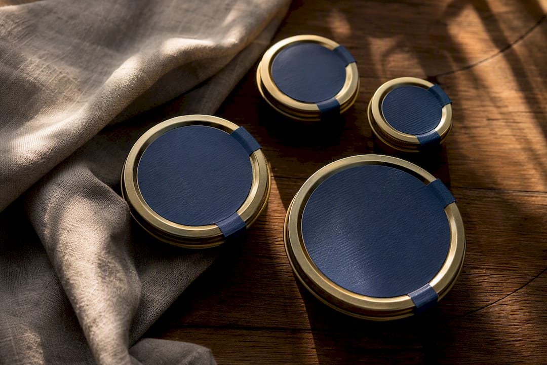 Range of caviar tin sizes on dark surface