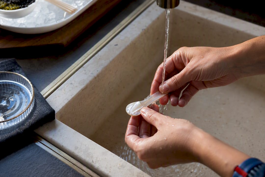 Mother-of-pearl spoon being washed by hand