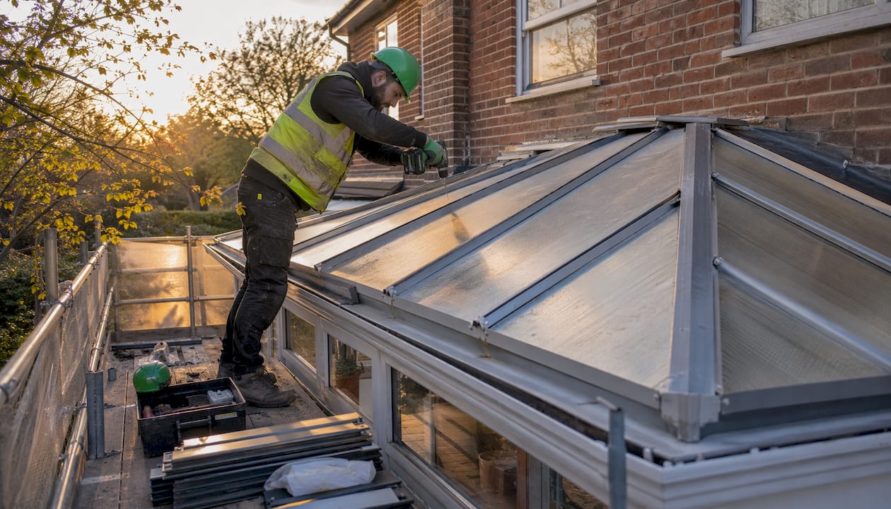 Roofer replacing conservatory roof outdoors