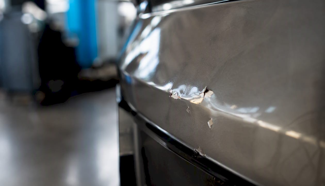 Close-up of dented car panel paint damage