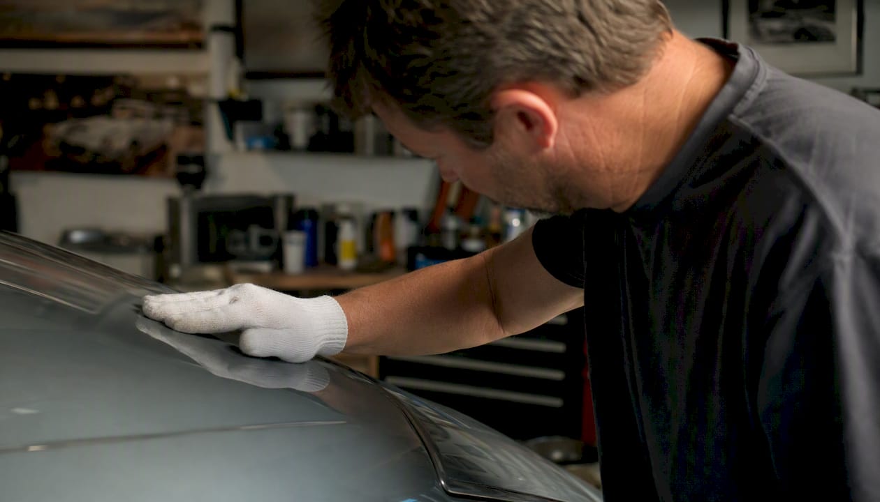 Classic car owner touching original paint finish