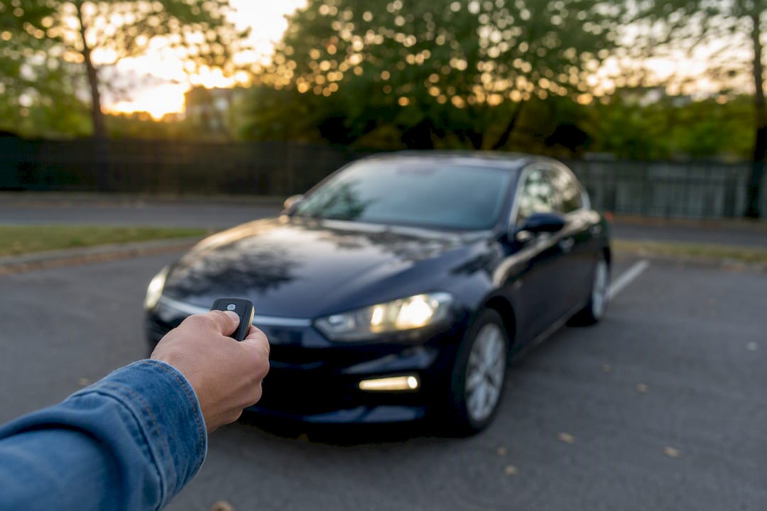 Hand holding rental car key inside vehicle