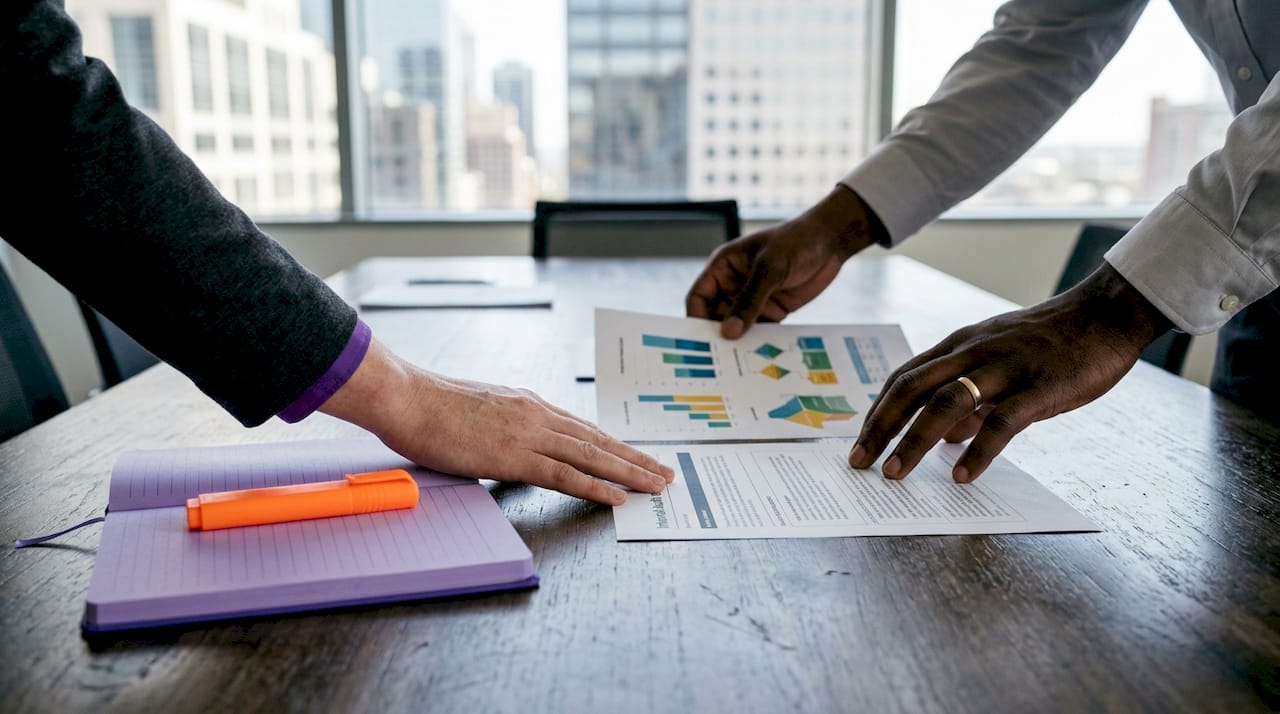 Hands organizing ISMS review data inputs