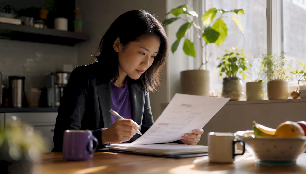 Woman reviewing ISMS framework document at desk