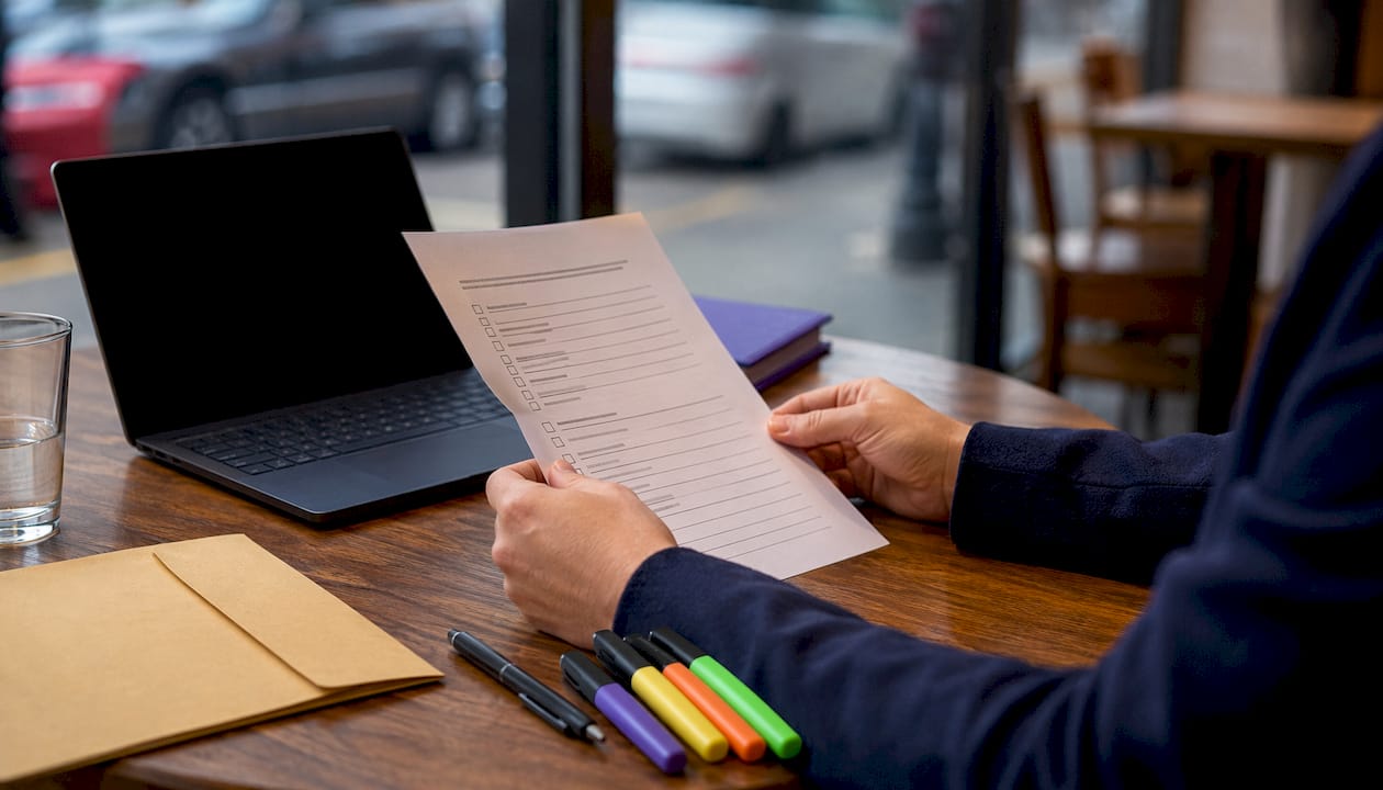 Hands holding PCI DSS compliance checklist
