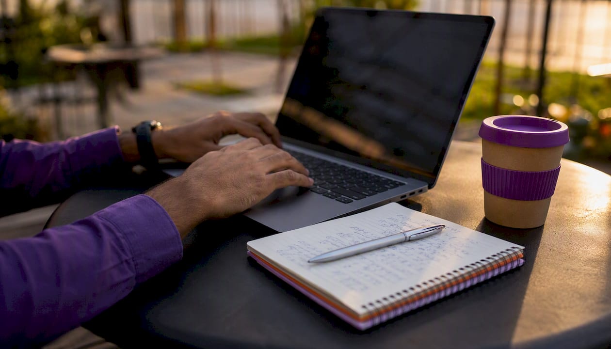 Hands typing on laptop in co-working space