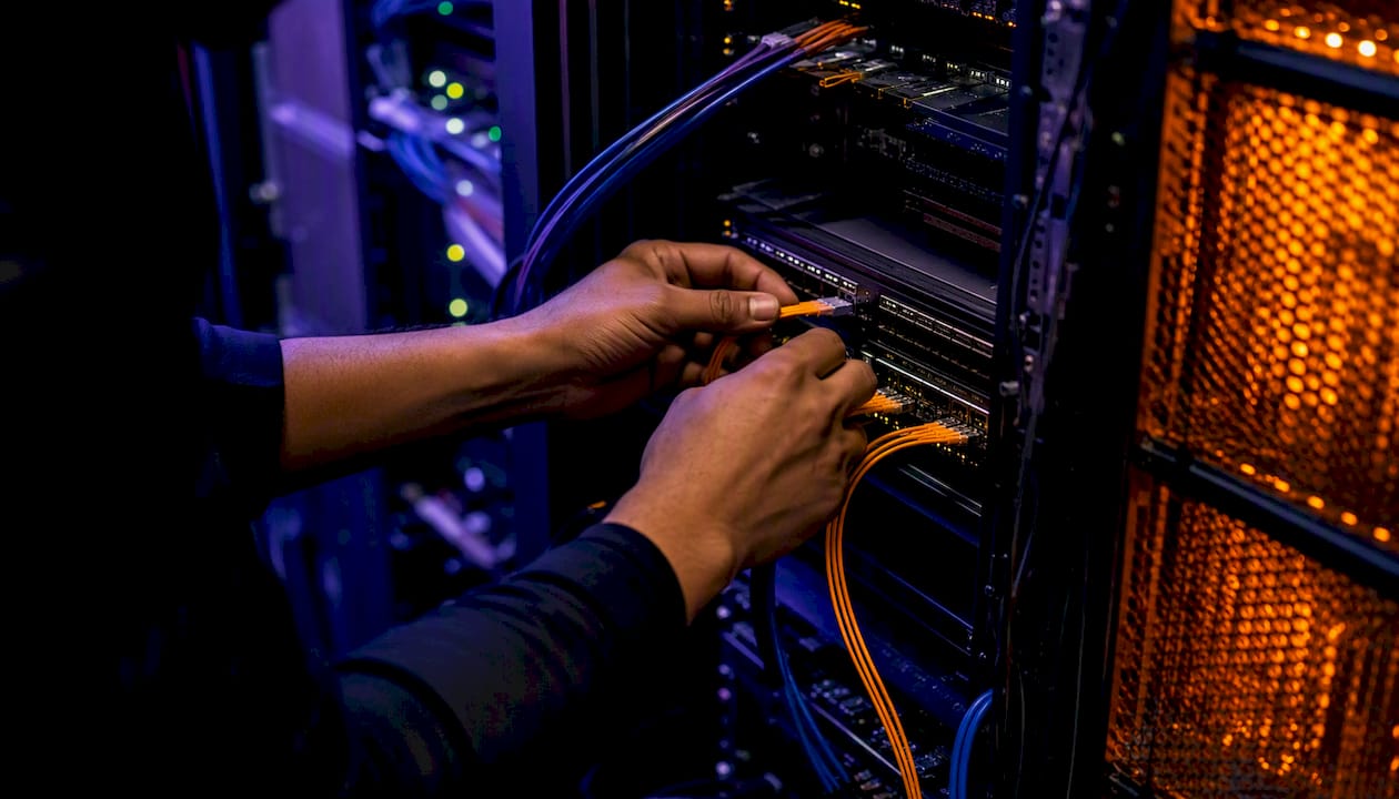 Network engineer plugging a cable into server