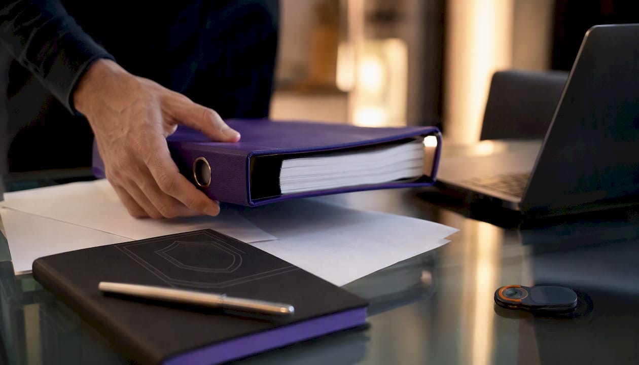 Hand placing risk treatment plan folder on desk
