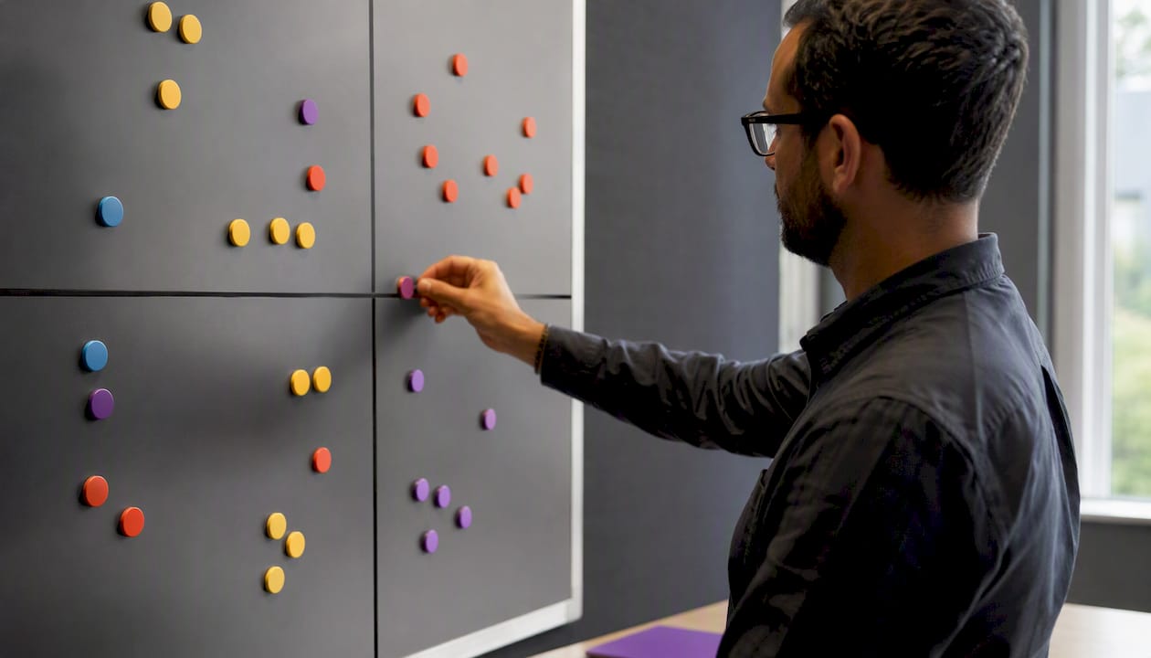 Hand placing magnet on internal audit schedule board