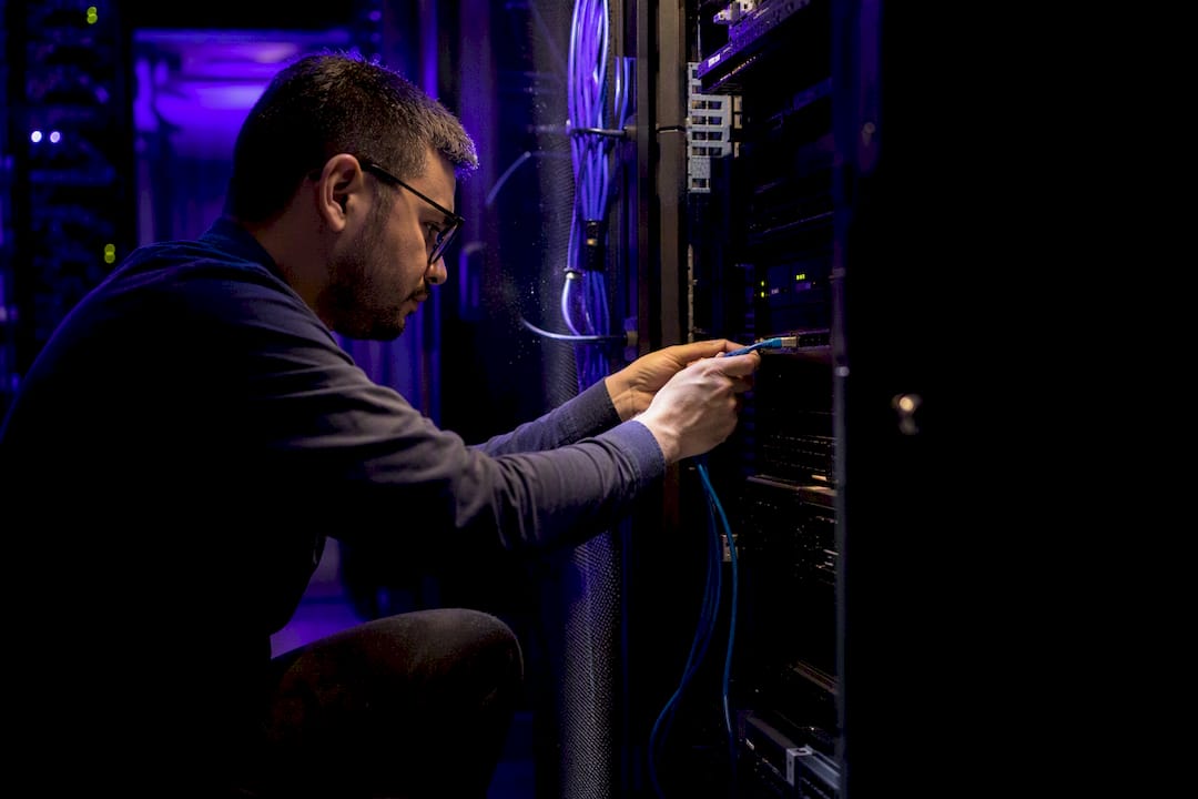 Hands connecting network cable in server room