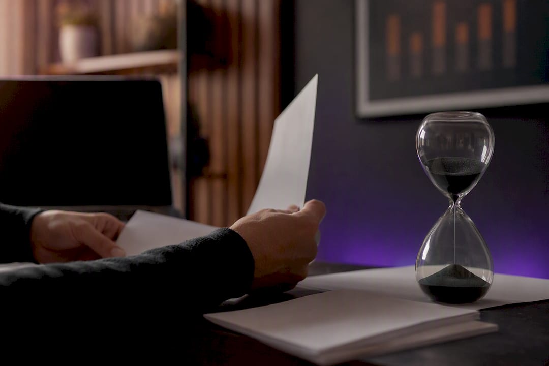 Hands managing ISO 27001 process tools on desk