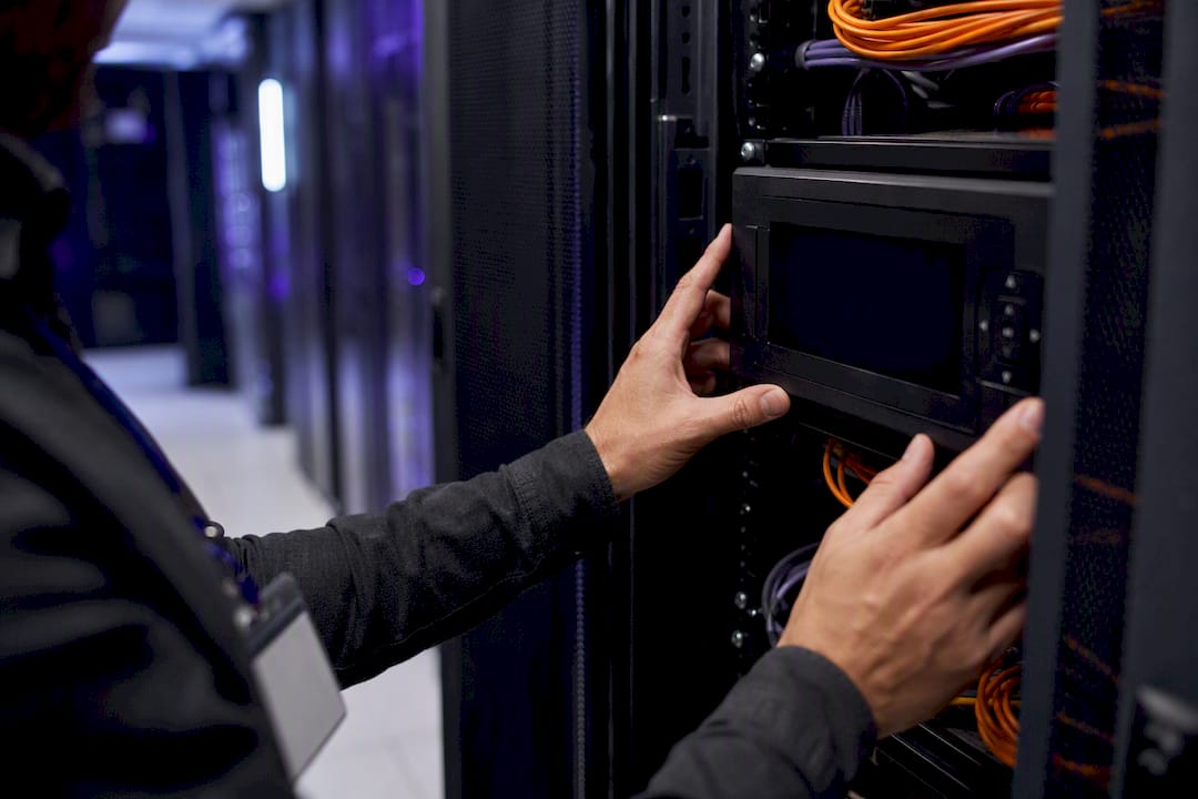 Hands adjusting security panel in server room