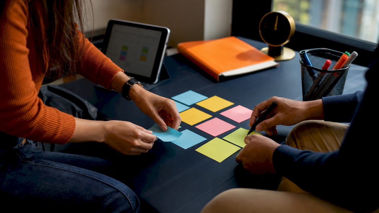 Hands organizing color-coded study schedule tools