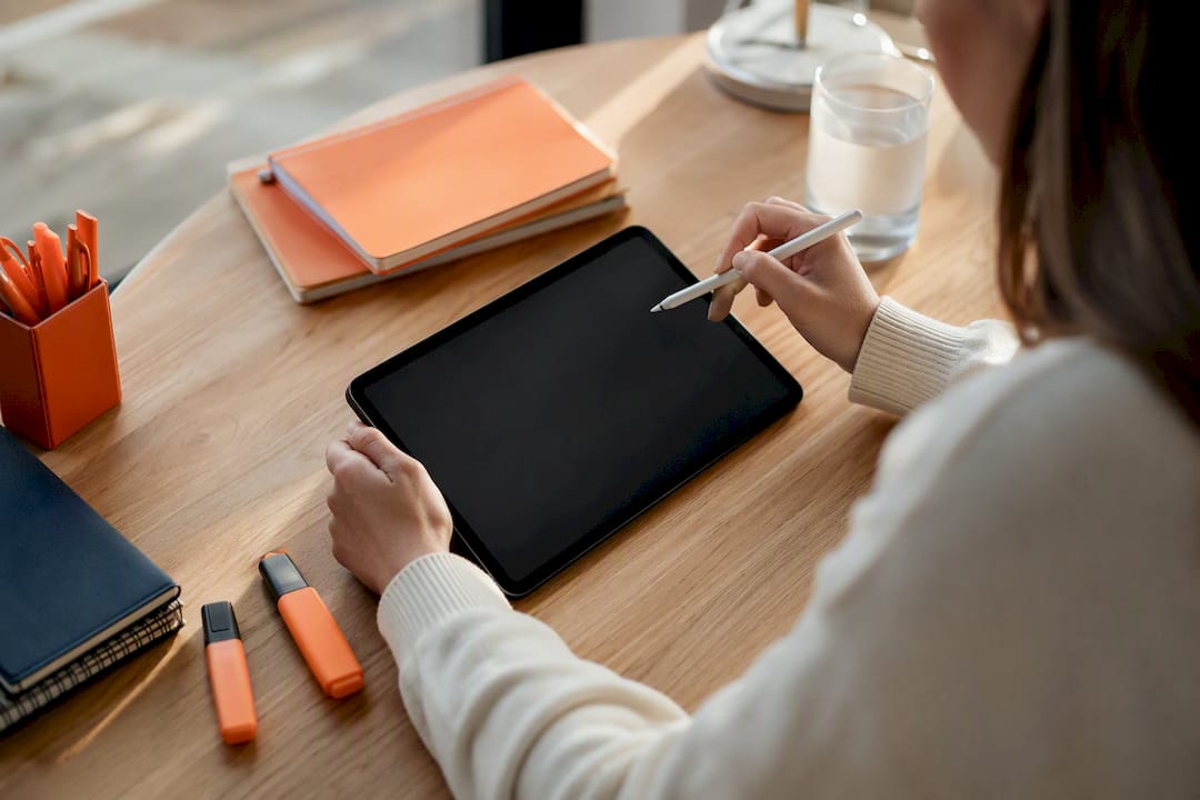 Hands with stylus poised over tablet for script editing