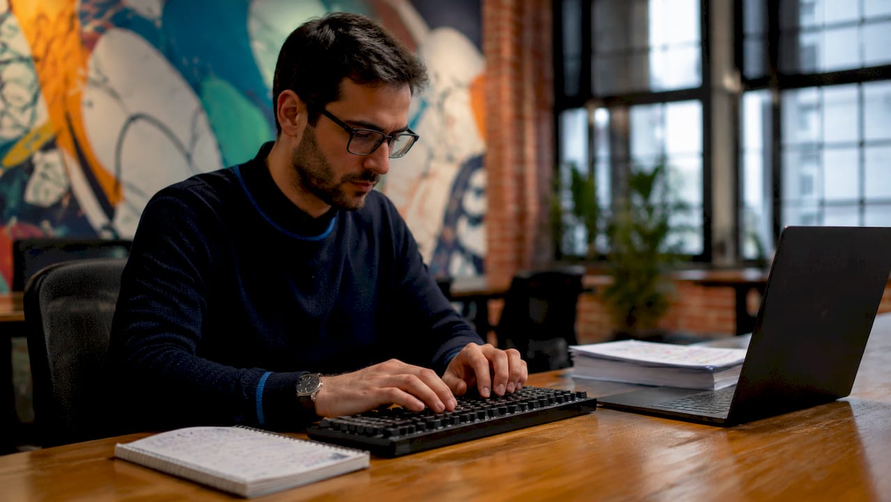 Hands typing on keyboard in spectral data analysis workspace