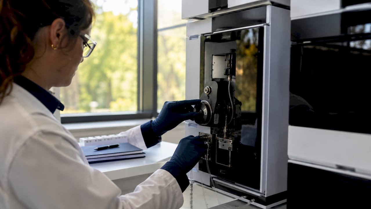 Hands adjusting chromatography instrument controls