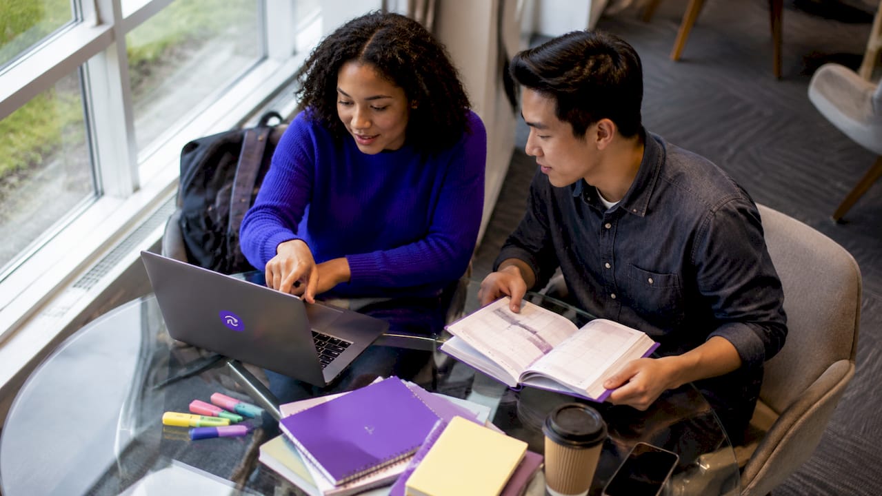 Group of students planning coursework together at café