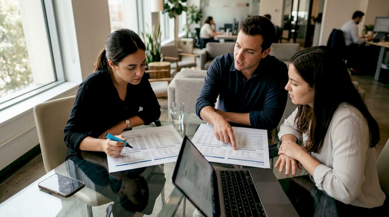 Hands comparing bond coupon and yield documents at table