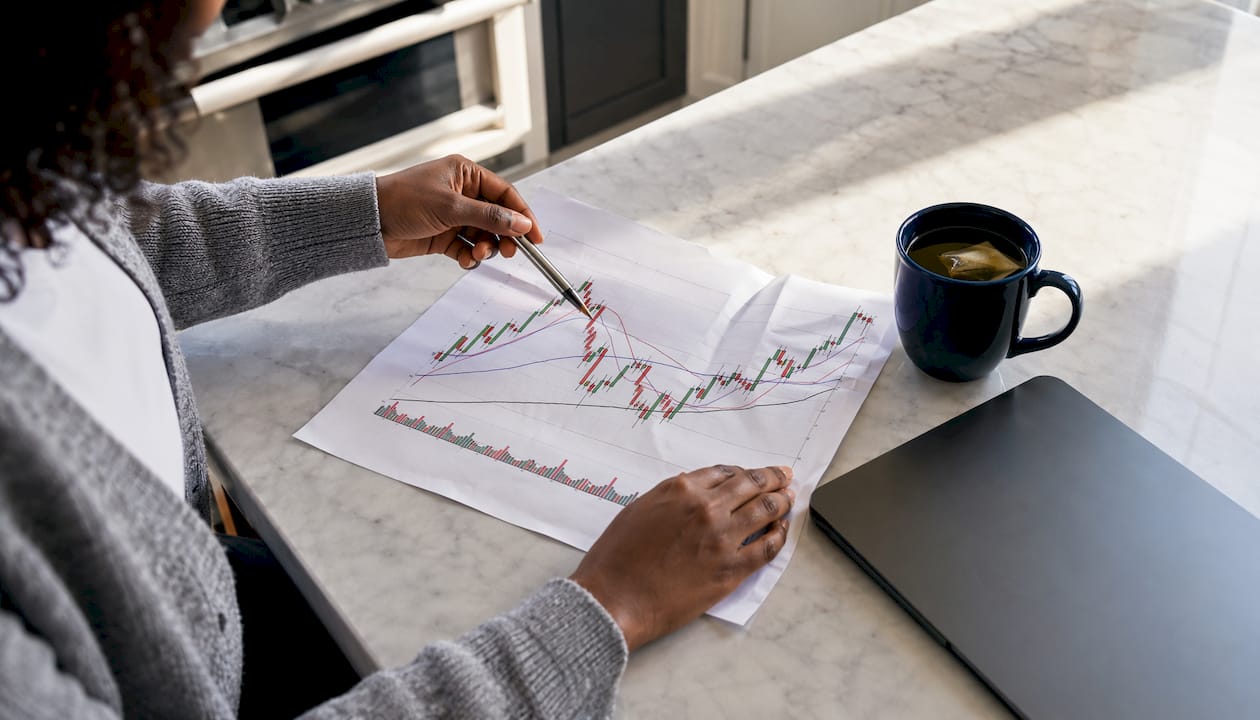 Hands examining trading chart patterns