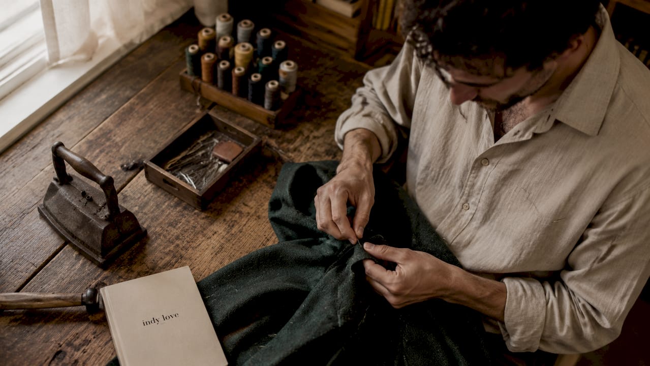 Hands sewing wool crepe blazer sleeve closely