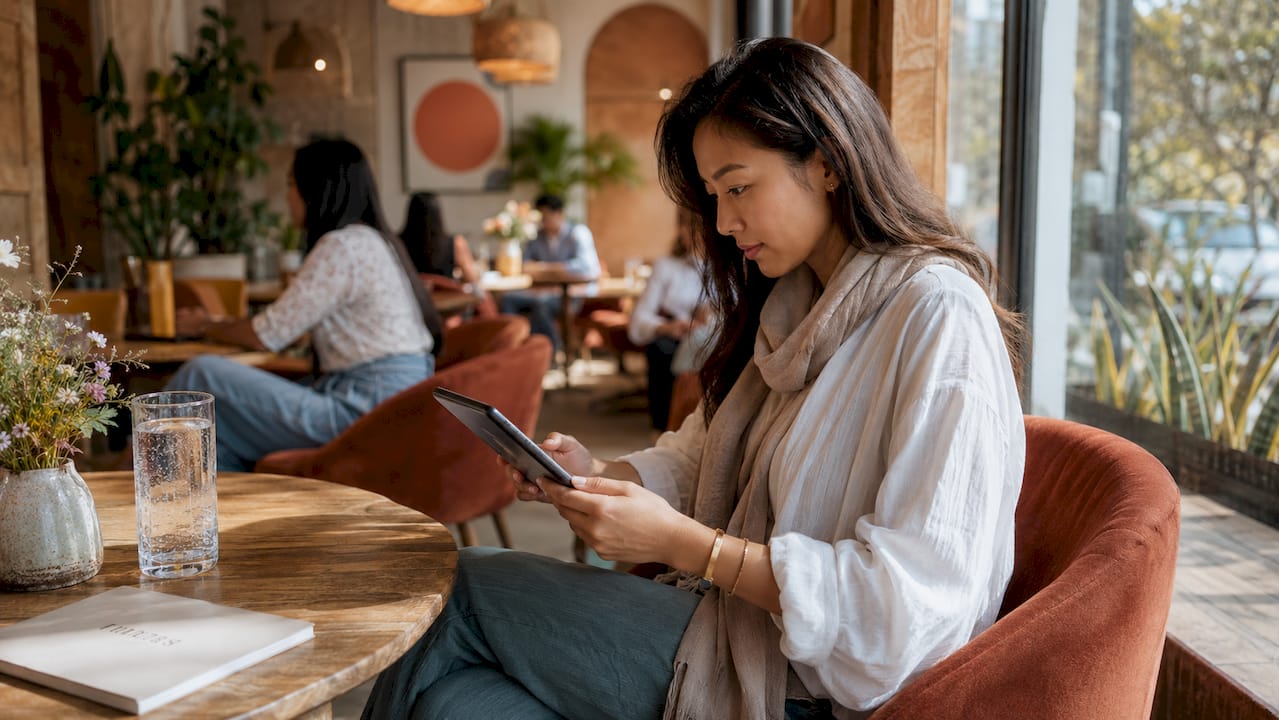 Woman browsing luxury women's clothing on smartphone