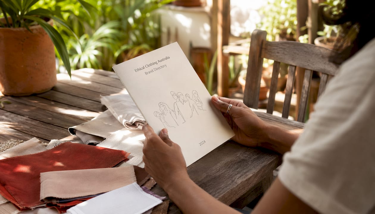 Hands holding ethical clothing brand directory