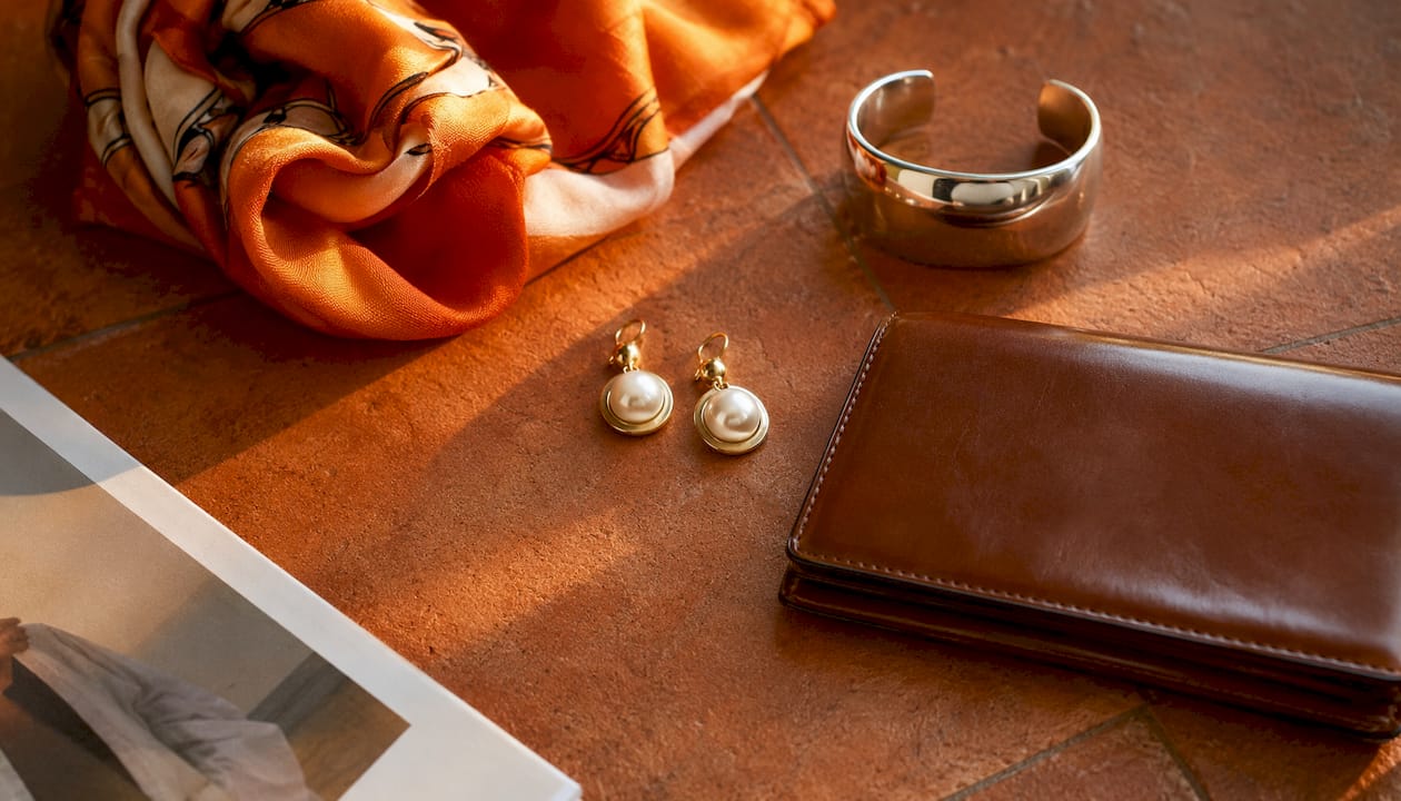 Flat lay of diverse fashion accessories on wooden floor