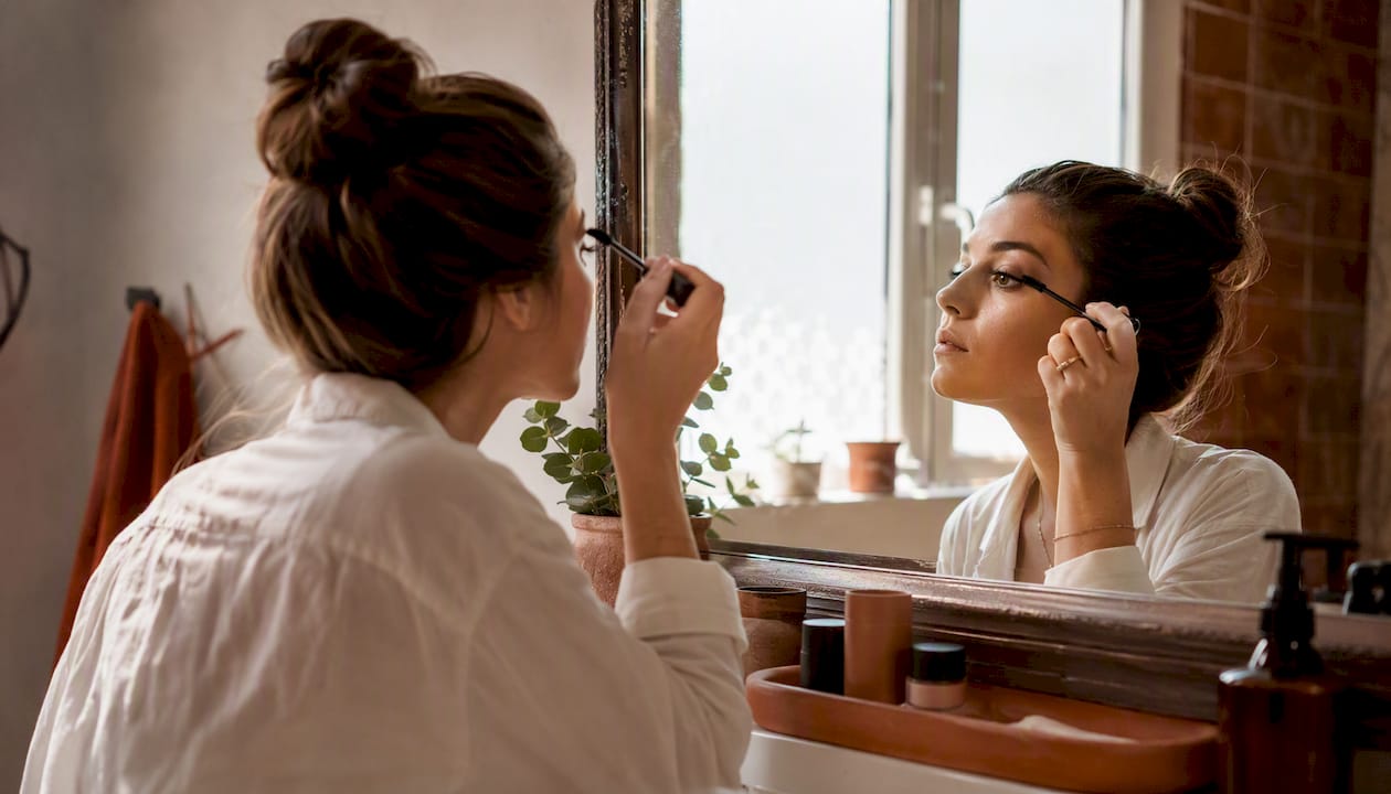 Woman applying neutral mascara makeup