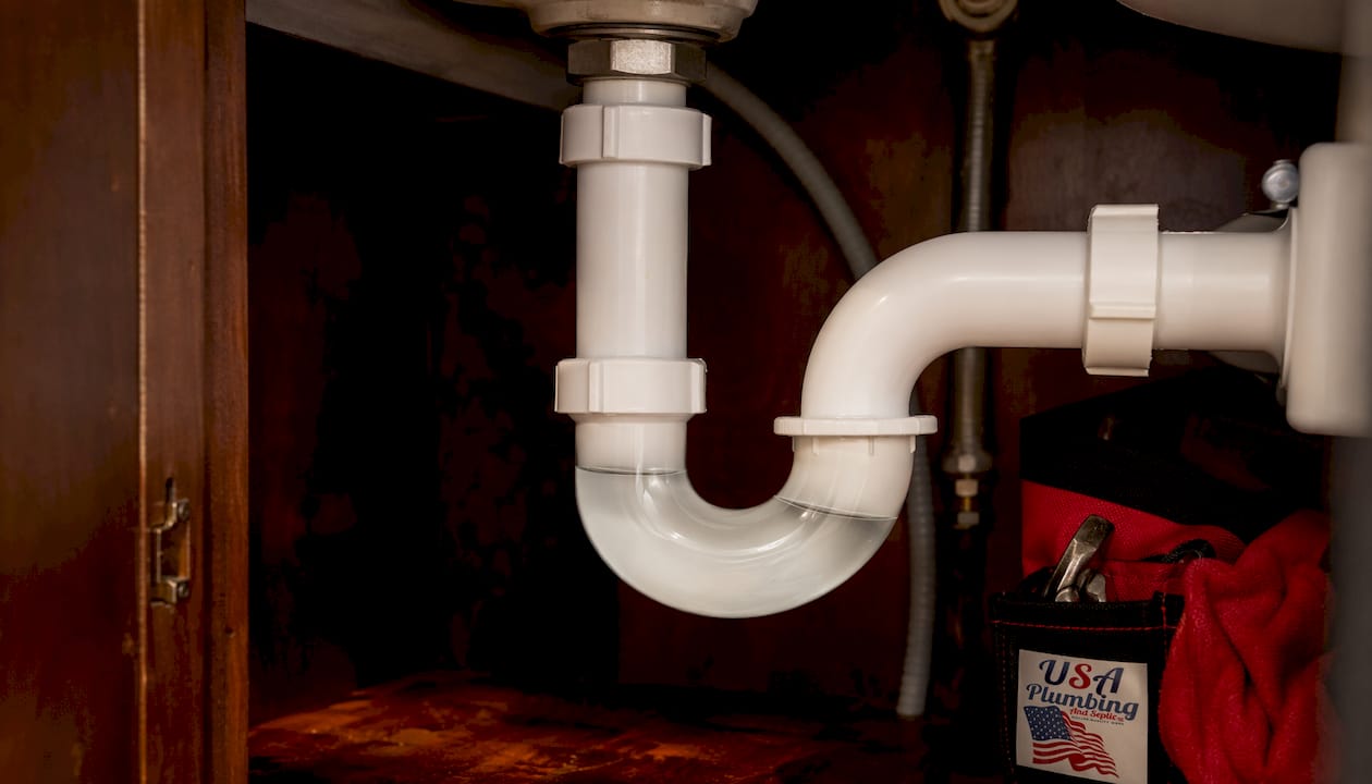 Close-up of P-trap plumbing pipe under sink