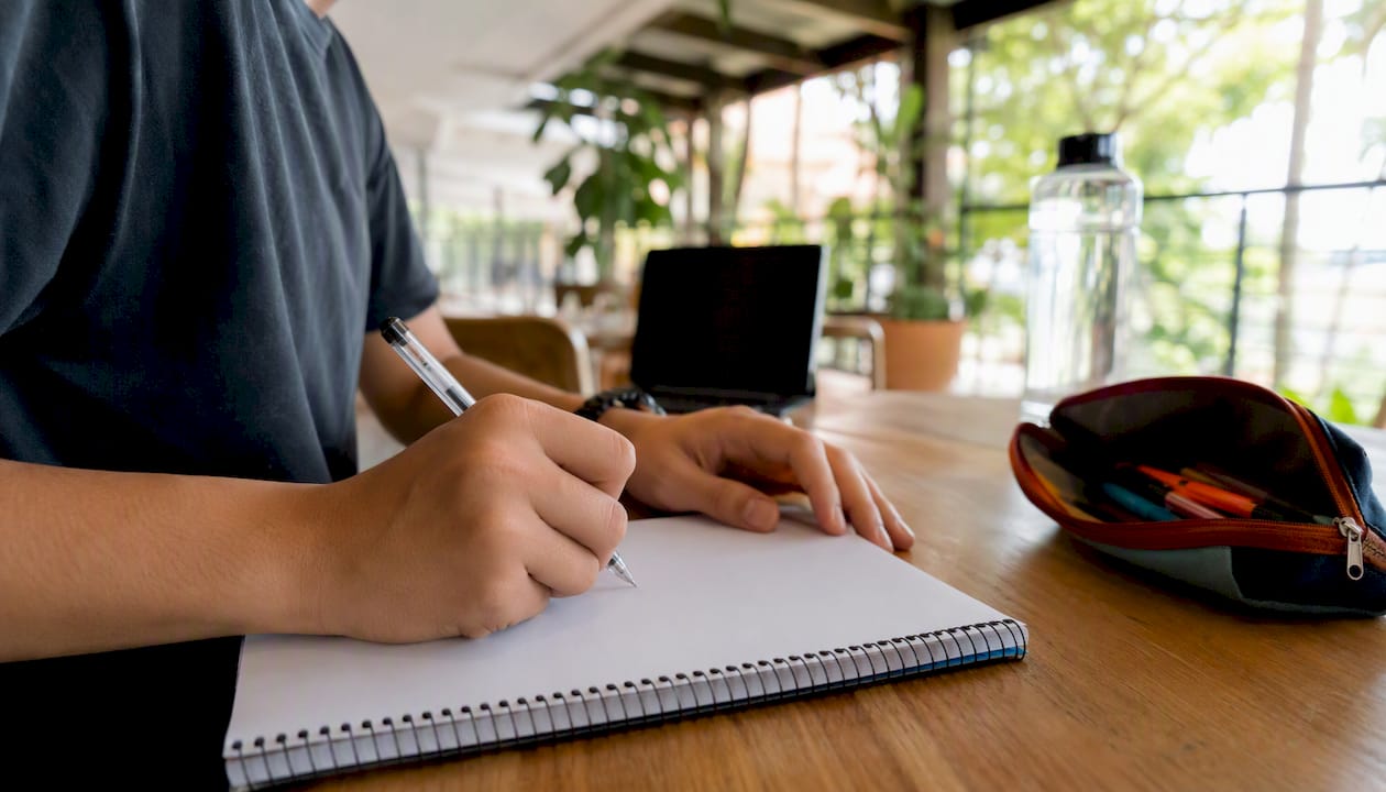 Alumno que mejora su inglés practicando phrasal verbs y tomando apuntes