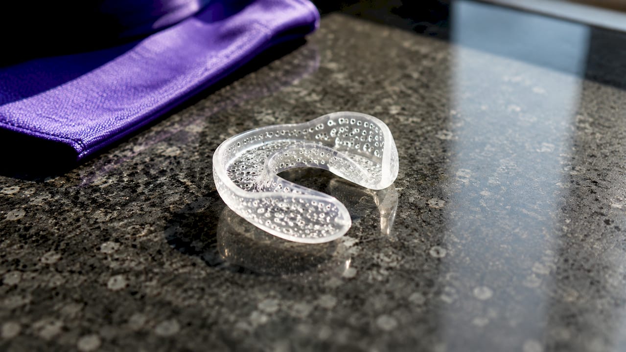 Close-up of perforated ventilated mouth guard on wooden surface